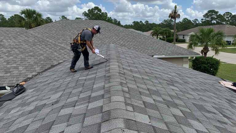 Florida roofer inspecting aging asphalt shingles on a residential home for signs of storm damage and wear.
