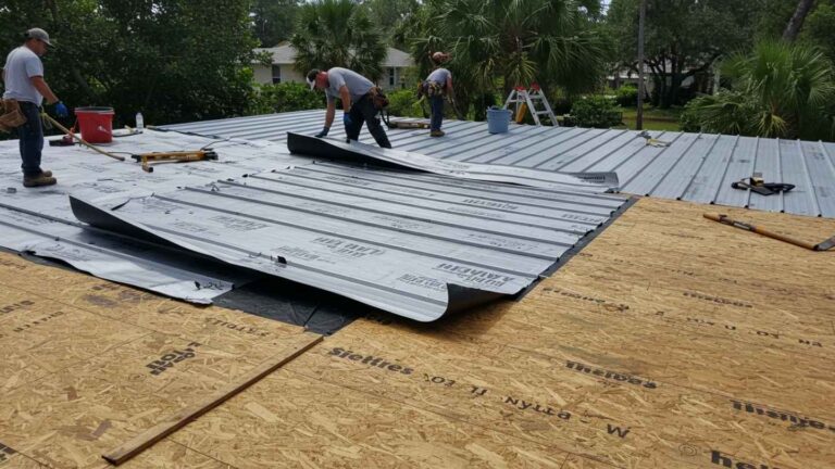 Roofers install synthetic underlayment on Florida home before adding metal roof panels under sunny tropical skies.