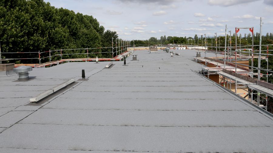 Licensed flat roofing contractors installing durable, energy-efficient system on commercial property.
