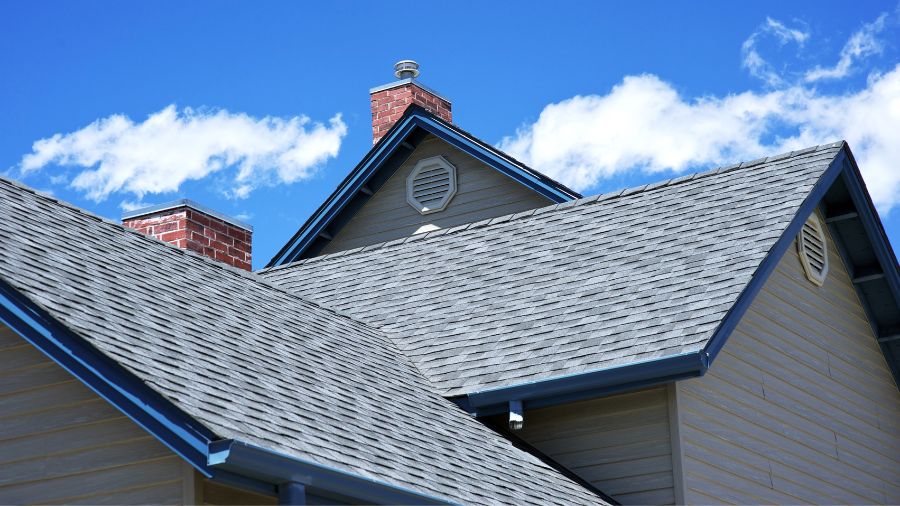 Residential roofing contractor installing asphalt shingles on a home