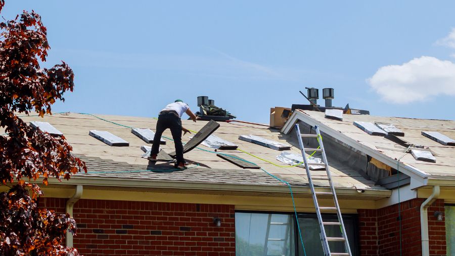 Licensed roofing contractor performing roof inspection for replacement.